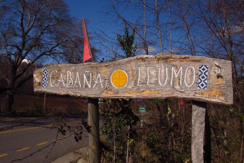 a wooden sign that says elena leona on a street at Cabañas leumo in Manzanar