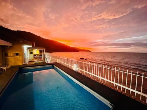 a swimming pool on a cruise ship with a sunset at Private Beach-front Haven by StayCo - Seaview Pool, KTV & Speaker System, Beach Air Loft, Private Beach Access and Beyond! in Tanjung Bungah