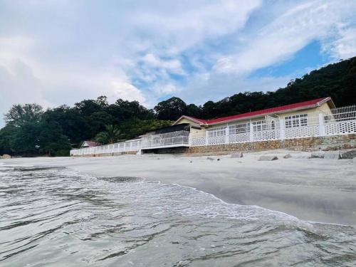 a building on the beach next to the water at Private Beach-front Haven by StayCo - Seaview Pool, KTV & Speaker System, Beach Air Loft, Private Beach Access and Beyond! in Tanjung Bungah
