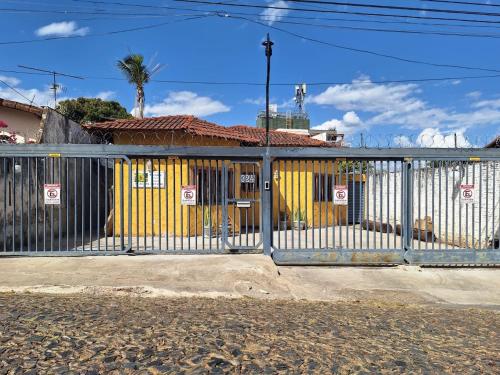 a gate in front of a yellow and white building at Recanto Pau Brasil in Sete Lagoas