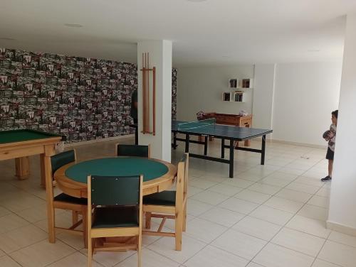 a room with two ping pong tables and chairs at O melhor e + aconchegante AP de SPA (custo/benefício) in São Pedro da Aldeia