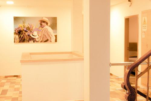 a painting of a man in a hat on a wall at Hotel Yivinaca in Barranquilla