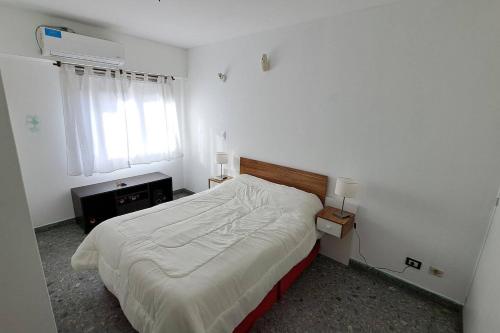 um quarto branco com uma cama e uma janela em Departamento amplio y luminoso em Buenos Aires