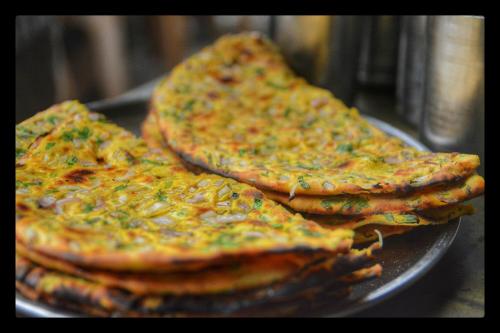 dos rebanadas de pizza sentadas en un plato en Collection O Hotel Regal Near ISKON TEMPLE , ABIDS en Hyderabad