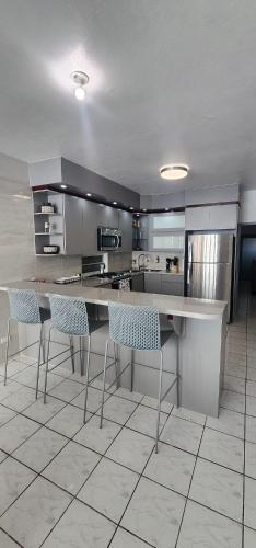 a kitchen with a counter and chairs in it at Kali-Yaiti Casa Vacacional in Vega Baja
