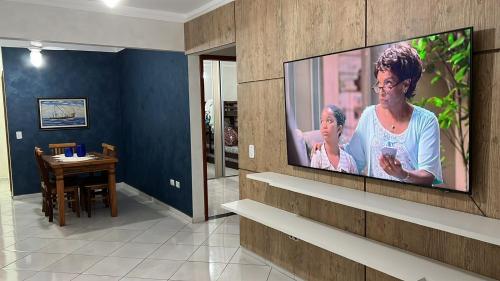 ein Wohnzimmer mit einem Flachbildfernseher an der Wand in der Unterkunft Praia Grande - Condomínio Grygor in Praia Grande