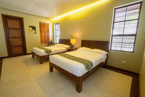 a bedroom with two beds and a window at The Asri Dive and Leisure Resort in Batangas City