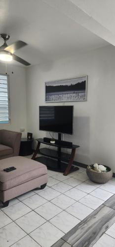 a living room with a flat screen tv and a couch at Kali-Yaiti Casa Vacacional in Vega Baja