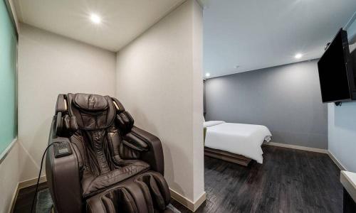 a room with a room with a chair and a bed at Anyang ILLOWA Hotel in Anyang