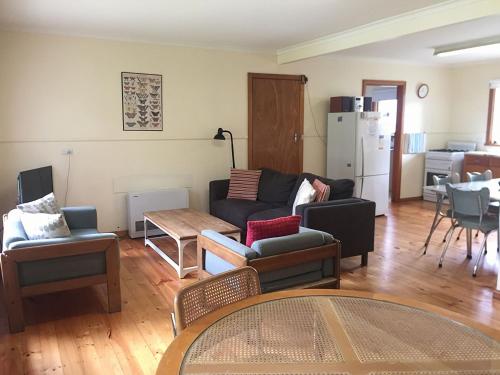 a living room with a couch and chairs and a table at The Beach Shack in Queenscliff