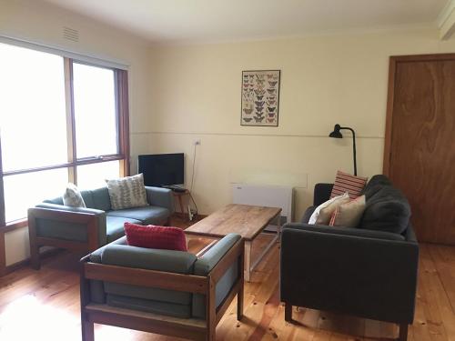 a living room with two couches and a table at The Beach Shack in Queenscliff
