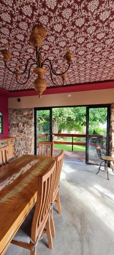 a dining room with a wooden table and a stone wall at Pousada Lajedo in Serra de São Bento