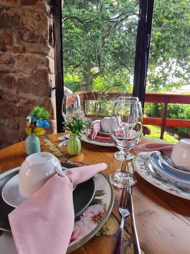 una mesa de madera con platos y copas de vino. en Pousada Lajedo, en Serra de São Bento