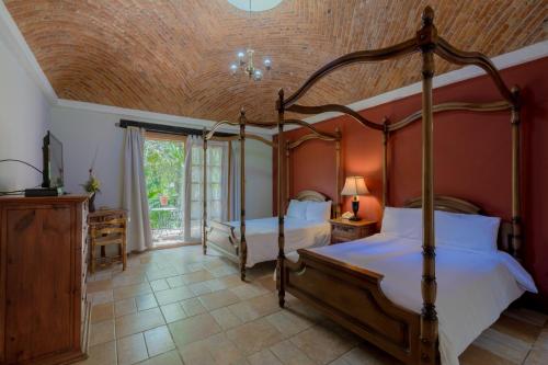 a bedroom with two beds and a wooden ceiling at Atotonilco Hotel & Club in Atotonilco