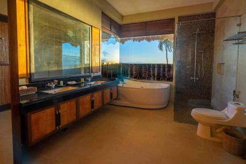 a bathroom with a tub and a sink and a bath tub at The Asri Dive and Leisure Resort in Batangas City