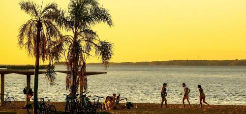 a group of people walking on the beach near the water at Monoambiente céntrico con balcón - Posadas, Misiones in Posadas