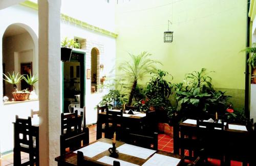 a dining room with tables and potted plants at Hotel Belen in Popayan