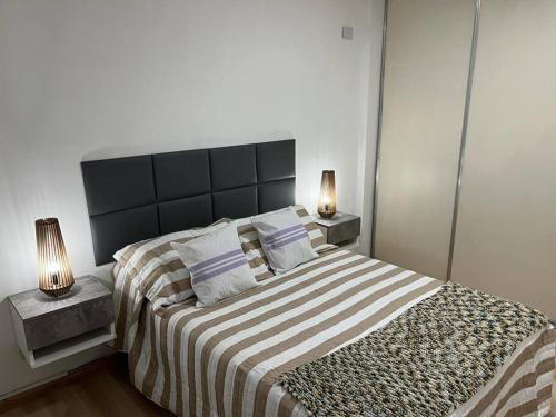 una camera da letto con un grande letto con una coperta a righe di Precioso Departamento en Caballito a Buenos Aires