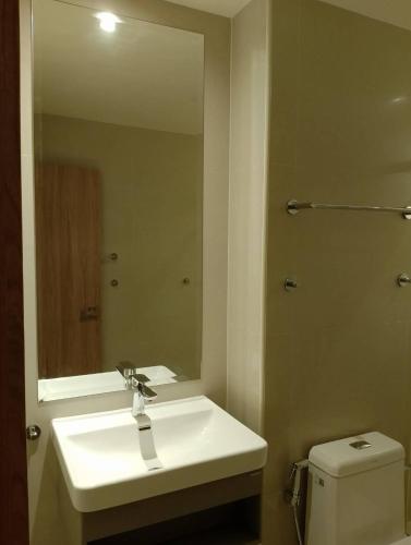 W łazience znajduje się umywalka, lustro i toaleta. w obiekcie Westerly Hill Pattaya w mieście Pattaya Central