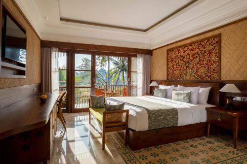 una camera d'albergo con letto, scrivania e balcone di Arkamara Dijiwa Ubud ad Ubud