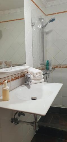 y baño con lavabo blanco y espejo. en Apartamentos JANESKA, en Tías