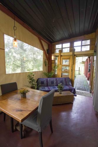 a living room with a wooden table and a couch at El Rincon Eco Hotel in Los Ángeles