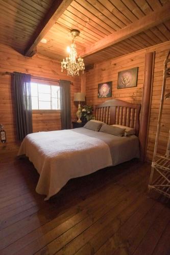 a bedroom with a large bed in a cabin at El Rincon Eco Hotel in Los Ángeles