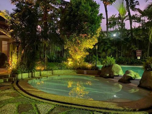 a small swimming pool in a yard with trees at Stylish 2BR w/ Free Pool Access and Parking LG03 in Manila