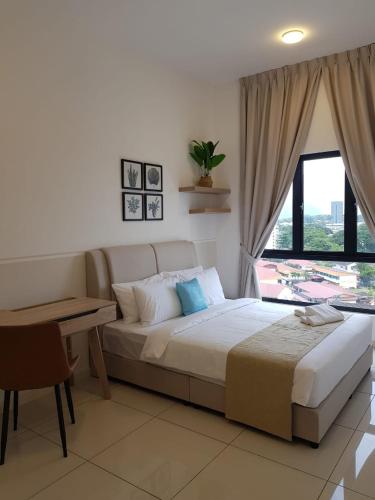 a bedroom with a bed and a table and a window at The Horizon by MyKey in Ipoh