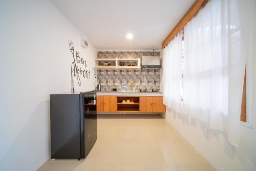 a kitchen with a black refrigerator in a room at Danka Vacation Home in Seribu
