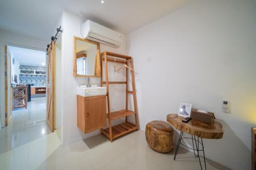 a bathroom with a sink and a wooden stool at Danka Vacation Home in Seribu