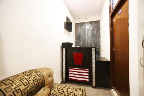 Garhi Harsāru的住宿－OYO Flagship 44151 Royal Guest House，客厅配有椅子和墙上的绘画