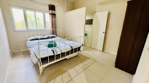1 dormitorio con cama y ventana en Homely 3 bedroom apartment perfect for your dream getaway!, en Port Vila