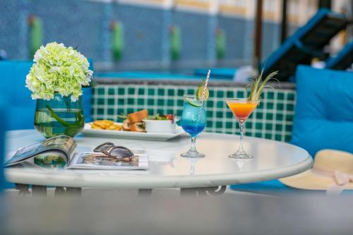 a table with two glasses and a plate of food at La Charm Hoi An Hotel & Spa in Hoi An