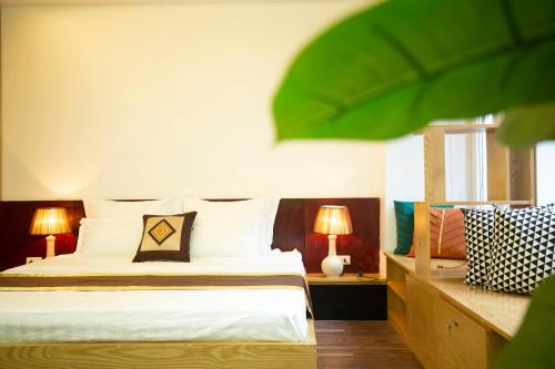 a bedroom with a bed with two lamps and two tables at Sumitomo12- 535 Kim Mã Apartment for Japanese in Hanoi