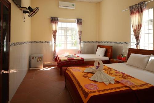 a hotel room with two beds and a window at Đức Anh Bungalow in Phu Quoc