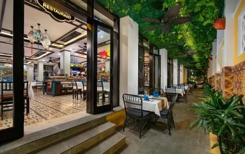 a restaurant with tables and chairs inside of it at La Charm Hoi An Hotel & Spa in Hoi An