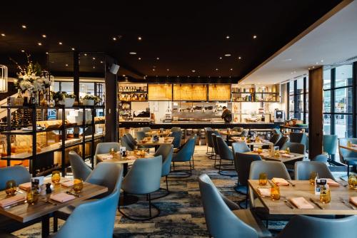 ein Restaurant mit Tischen und Stühlen und eine Bar in der Unterkunft Peppers Waymouth Hotel in Adelaide