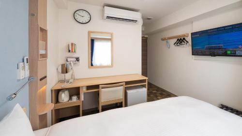 a bedroom with a bed and a desk with a clock at Toyoko Inn Tenri Ekimae in Tenri