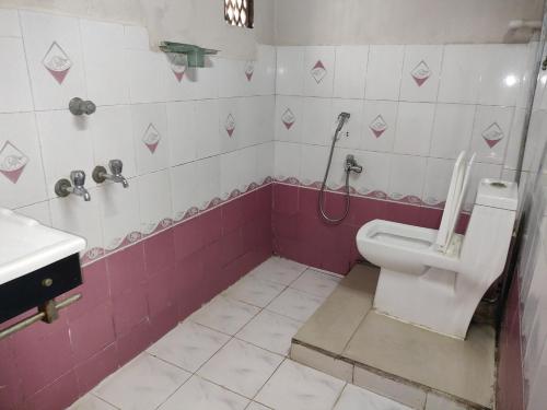 a bathroom with a toilet and a sink at Hotel Karthikeya Residency in Kākināda