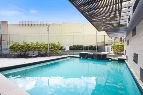 a swimming pool in front of a building at Brisbane City Luxe 3-Bd, Views, Pool, Car park in Brisbane