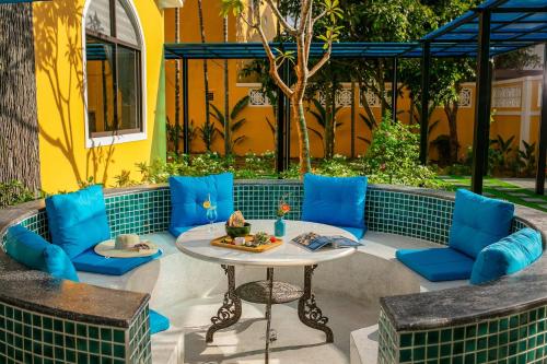 a patio with blue chairs and a table at La Charm Hoi An Hotel & Spa in Hoi An