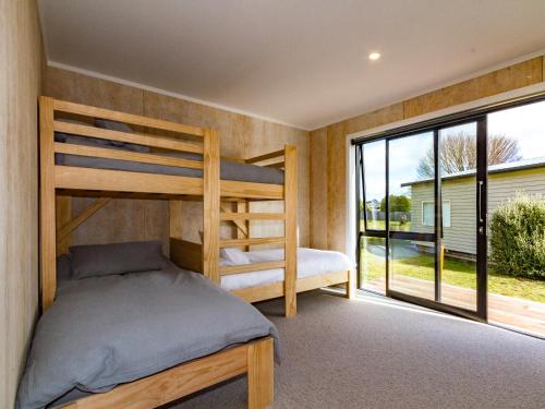 a bedroom with two bunk beds and a large window at Viewtopia - Ohakune Holiday Home in Ohakune