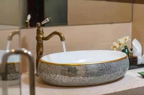 a sink with a faucet with water coming out at La Charm Hoi An Hotel & Spa in Hoi An