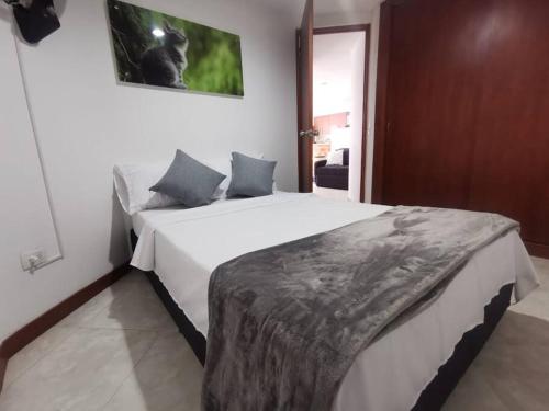 a bedroom with a large white bed in a room at Acogedor Apto Parque Sabaneta in Sabaneta