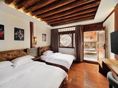 Habitación con 3 camas y ventana en Xilu Xiaoxie Inn, en Lijiang