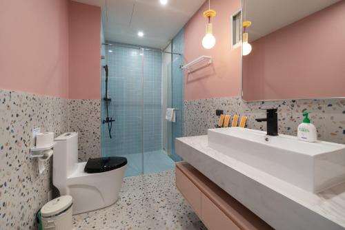 a bathroom with a sink and a toilet and a shower at 双層公寓 Duplex Apt. in Tainan