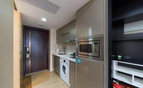 a kitchen with a washing machine and a washer at Manriver Executive Apartments in Guangzhou