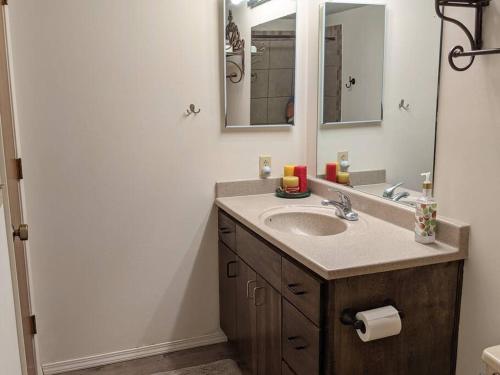 a bathroom with a sink and a mirror at Corner Lake Getaway in Bella Vista