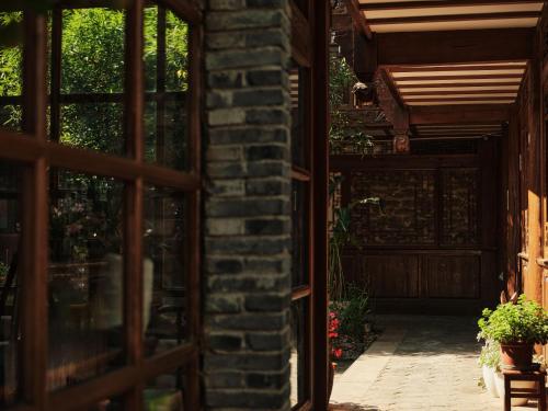 an entrance to a brick building with a wooden door at 夕露小榭古城南门店 Xilu Xiaoxie Inn Old Town Lijiang in Lijiang